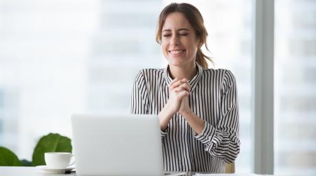 Hopeful woman in front of laptop